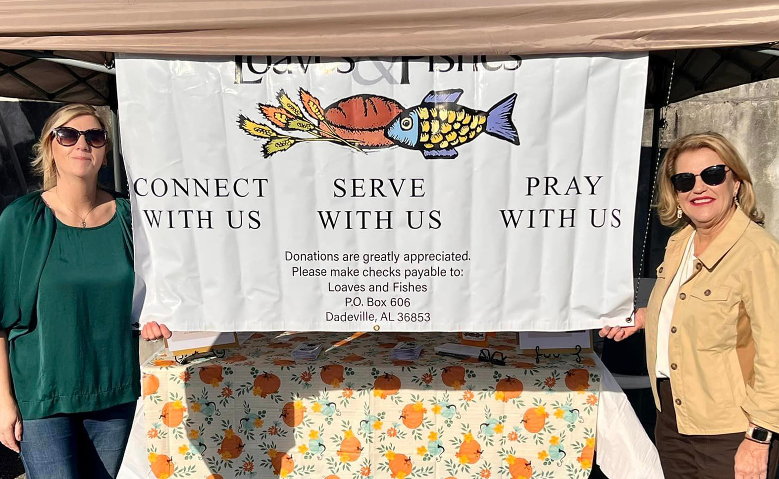 Volunteers at event with banner and canopy