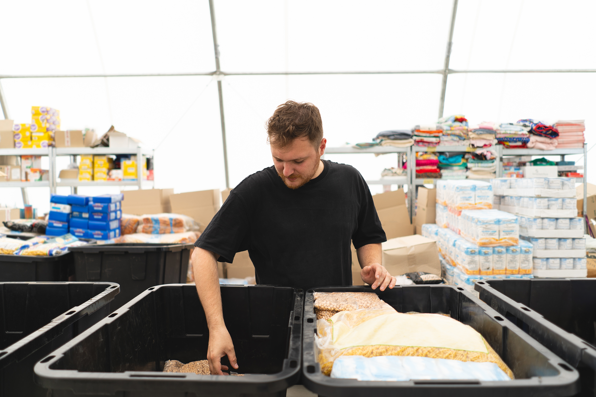 Volunteer man preparing donation boxes for people.